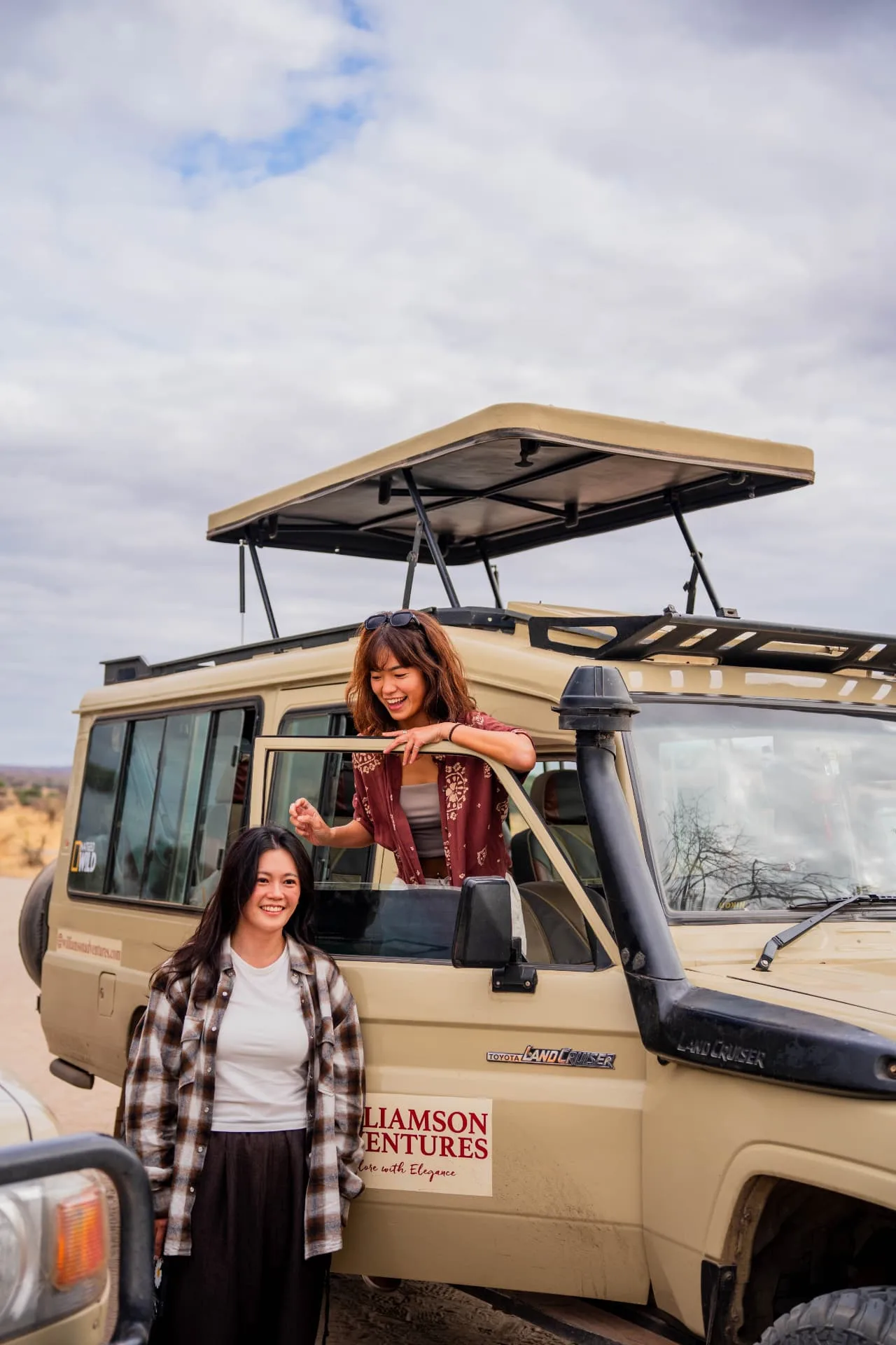 Guests by the open door of a Williamson Adventures Land Cruiser