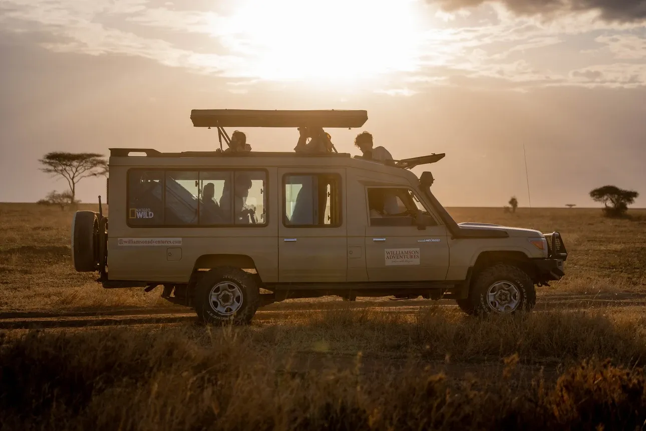 Williamson Adventures safari guests in a Land Cruiser on the Tanzania plains